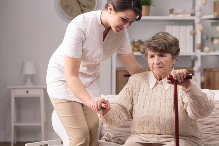 nurse helping elderly woman